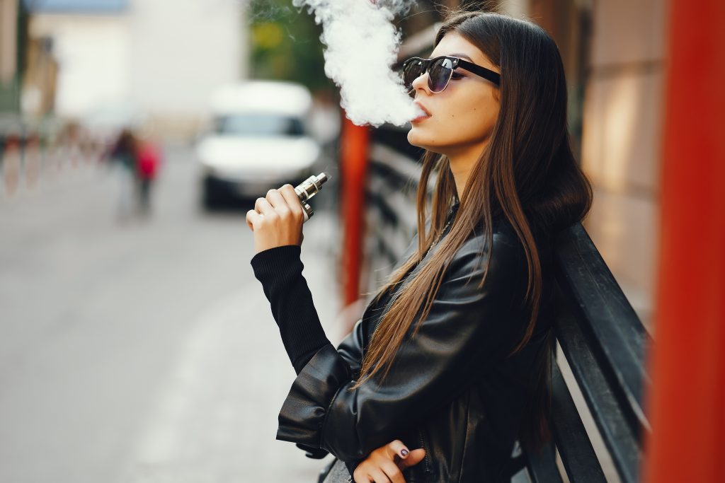 Accessoires de vape posés sur un bureau : étui, accus, chargeur