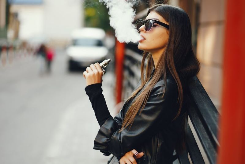 Accessoires de vape posés sur un bureau : étui, accus, chargeur