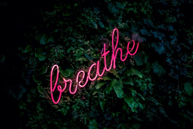 Néon lumineux affichant le mot Breathe, ambiance respiration et calme