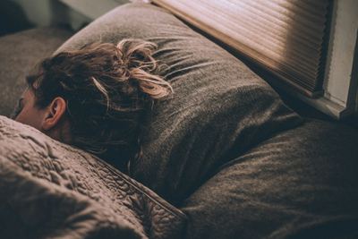 Personne endormie dans un lit, lumière tamisée