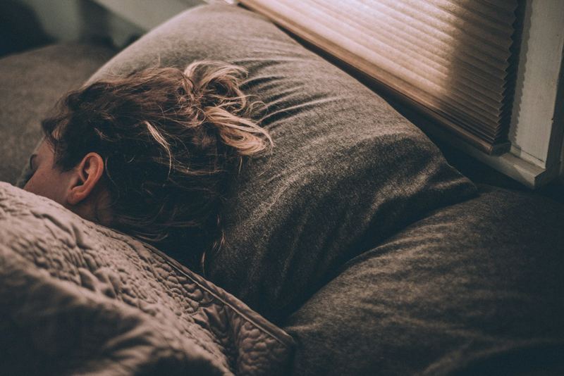 Personne endormie dans un lit, lumière tamisée